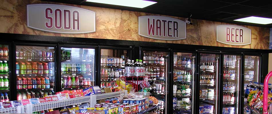 Convenience store coolers and custom signs hanging above.