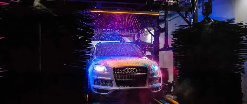 Car wash tunnel in Dallas, TX, with neon lights.